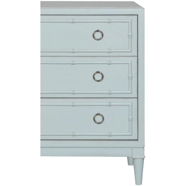 This beautifully detailed piece features carved bamboo details, turned legs, brushed nickel ring pulls and three drawers....