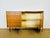 Vintage Scandinavian teak sideboard from the 1960s, featuring two storage doors with a shelf and five drawers. Gilded...
