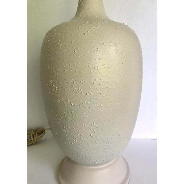 This is a stunning lamp from the mid-century that has a gorgeously modern shape and textured finish. The lamp is entirely...