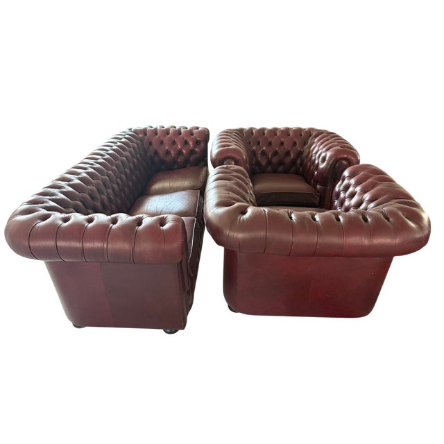 One three-seater sofa & two armchairs Genuine leather with deep button tufting. Chesterfield with rolled arms and studded...