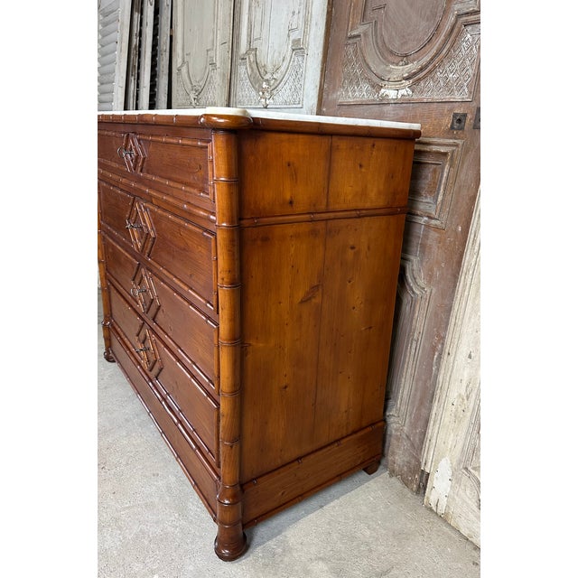 A late 19th-century faux bamboo style chest of drawers in fir. The front is decorated with bamboo elements in the frame...