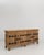 A Brutalist oak buffet featuring a solid wood structure with iron hardware accents. The piece is defined by its bold,...