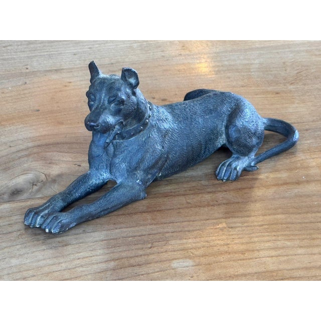 19th century Austrian bronze dog lying with forelegs stretched out and head raised, tongue lolling, ears pricked, wearing...
