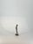 This charming bronze figurine captures a young woman in a moment of quiet curiosity, her hands gently clasped behind her...