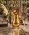 A polished brass pitcher featuring a bulbous body elevated on four ornate paw feet, paired with an elegant scrolled handle...