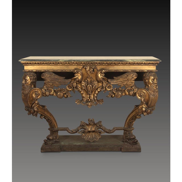 An impressive carved italian console table in the early 18th century style, the green marble top with moulded edge above a...