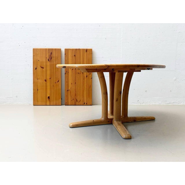 Extendable dining table made of solid pine, crafted in denmark in the second half of the 20th century, featuring a clear,...