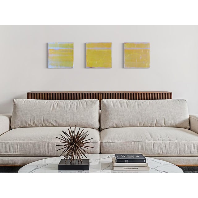 A soft chartreuse field runs across all three panels of this triptych, broken by faint vertical seams and traced with...