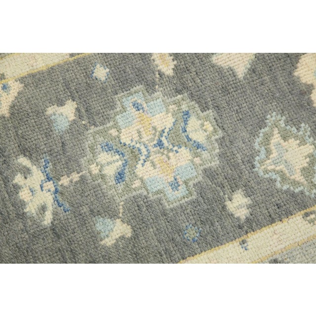 This modern Turkish Oushak rug is a stunning piece of art that has been handwoven using traditional techniques by skilled...