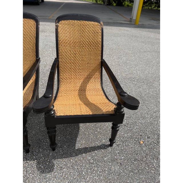 Antique Dutch Colonial Indonesian cane and wood plantation chairs from the 20th century with extending arms and turned...
