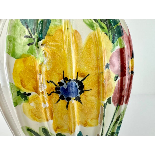 A lively hand-painted Italian ceramic vase featuring bold, expressive florals in sunlit yellow and deep red, accented with...