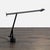 This Artemide desk lamp features a sleek black design with adjustable arms for flexible lighting. Perfect for workspaces...