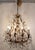 Design Plus Gallery presents an Italian Gilt Tole Crystal Chandelier of Vintage Age. The sculptural metal frame has...