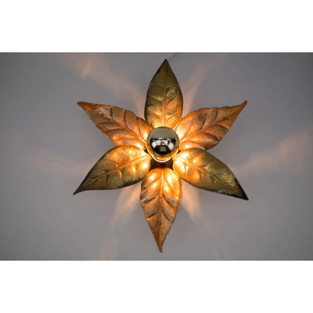 A gold wall light by belgian designer willy daro for lighting manufacturer massive. It has a wonderful naturalistic shape...