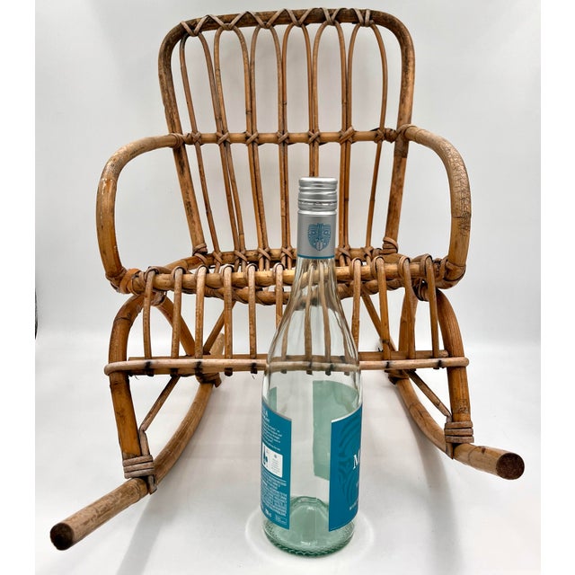 Vintage mid-century modern child's rattan and bamboo rocking chair. This distinctive design draws heavily from the iconic...