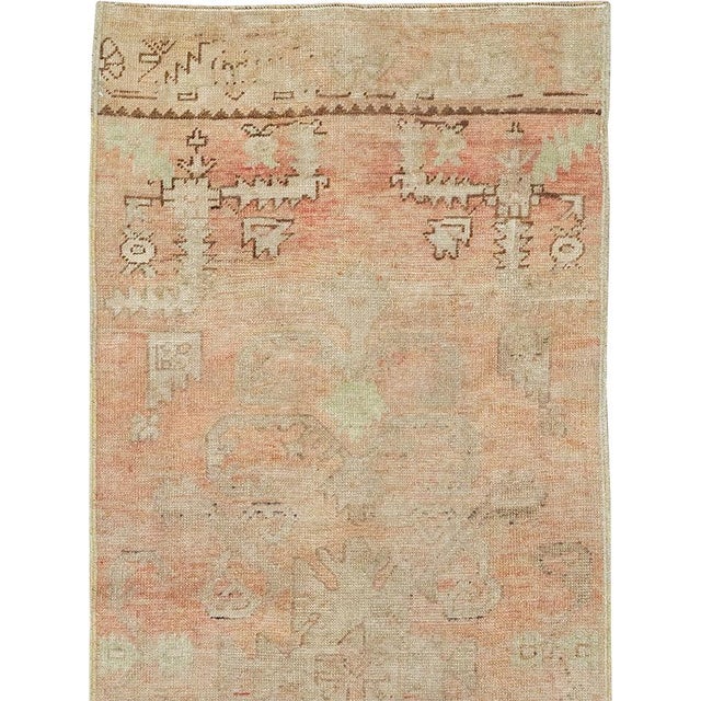 This mid-20th-century Turkish Anatolian runner presents a softly layered composition in warm apricot, pale salmon, sand,...