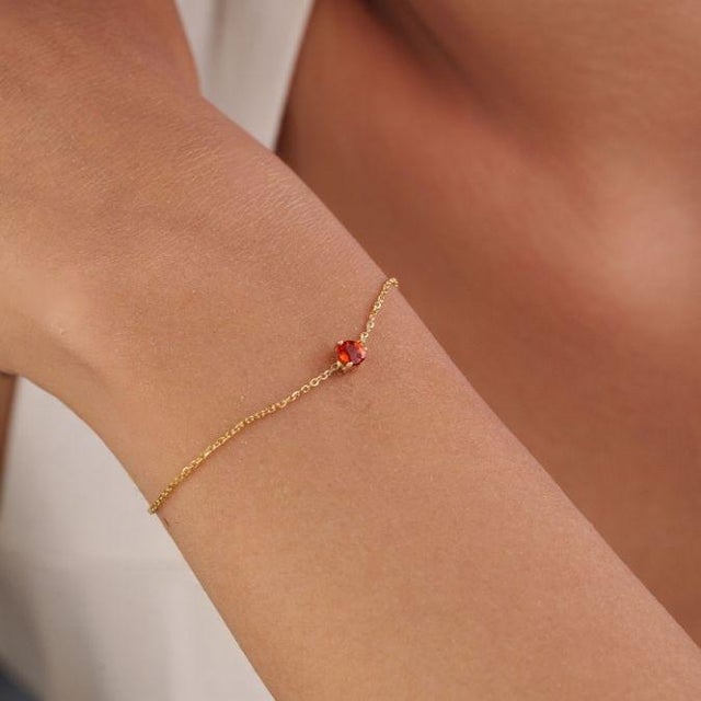 This delicate station chain bracelet features a 0.35 ct heart-shaped orange sapphire, set in 14K yellow gold. It measures...