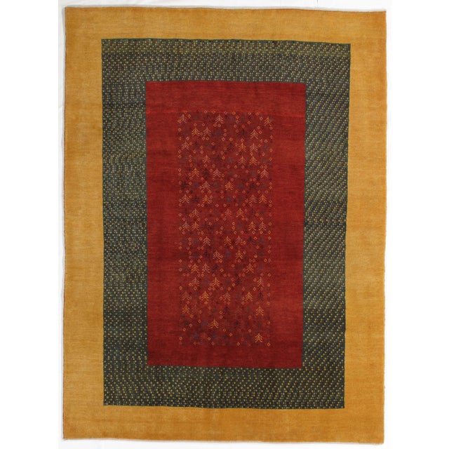 Vintage Hand-knotted Persian Lori Gabbeh rug featuring a rich red field with delicate allover tribal motifs, framed by a...