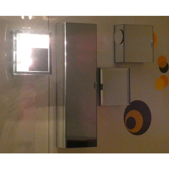 This set consists of four pieces: a five-spot wall light with a mirror, two square cabinets, and one rectangular cabinet....