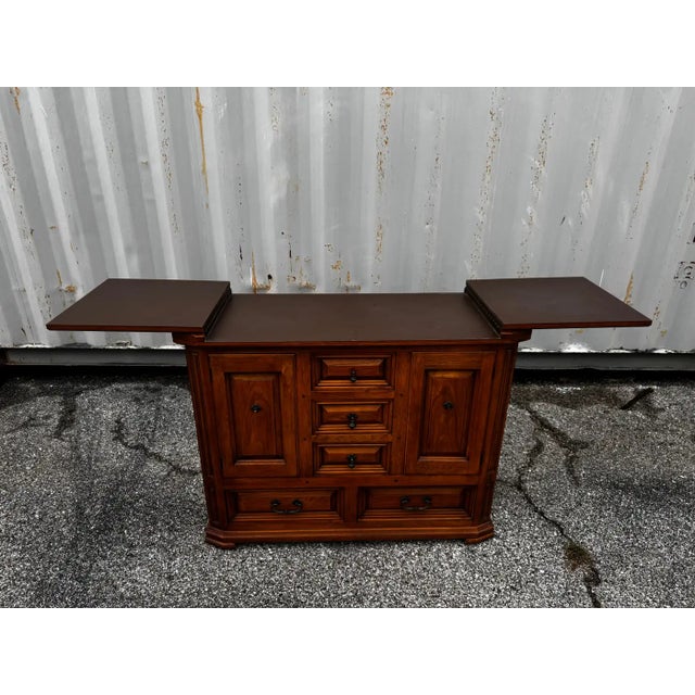 This flip top server has a rustic look. The top flips open to expand to 76.5". It's made of walnut and has 3 center...