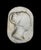 Large white marble sculpture depicting a woman's face in right profile, in a classical, neoclassical style. The modeling...