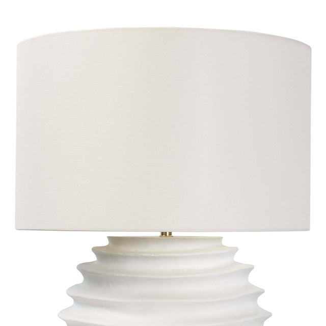 A tactile white finish on the Nabu table lamp accentuates its accordion-like base. Its simple air yet artisan feel would...