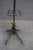 Ornate iron hall tree or coat rack featuring a decorative scrolling base, multiple coat and hat hooks, and an integrated...