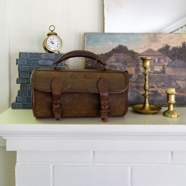 A pair of early 20th-century British Woods Lawn Bowls, complete in their original bowls bag. The wooden balls feature bone...