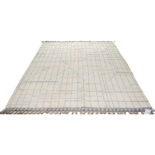 This hand knotted pile rug features a primary color palette of ivory, beige, cream, and white. Crafted from natural wool,...