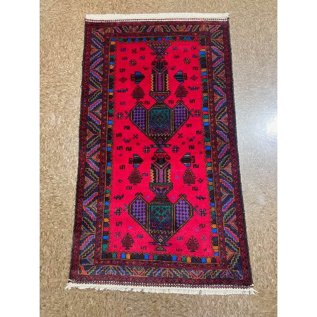 Hand-knotted Baluch rug, traditionally woven by tribal groups of eastern Iran and Afghanistan. Features a vivid magenta-...