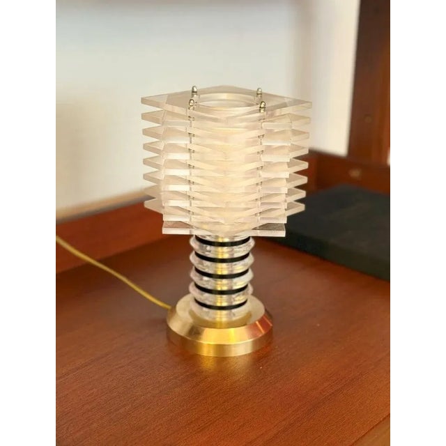 A rare compact table lamp from the late 1960s–70s Italian modernist period, combining Lucite with polished brass in an...