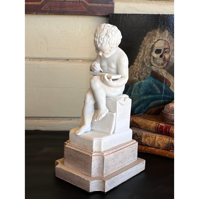 Early 20th century Italian porcelain bisque statue figurine of a "Putto Writing" after Canova. This piece is a classic...