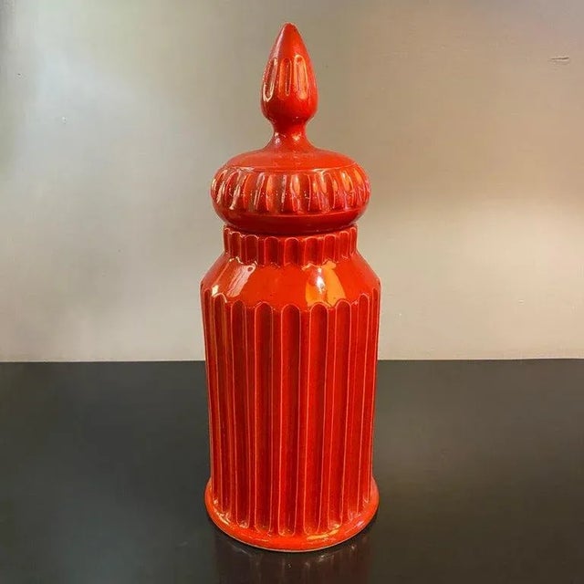 Mid-century, Italian, Moorish art pottery jar with lid in vibrant paprika red-orange. This glazed ceramic piece features a...