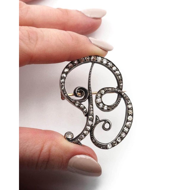 Diamond letter B brooch in silver and 18-karat gold. Large brooch forming the capital letter B. The letter is set with 66...