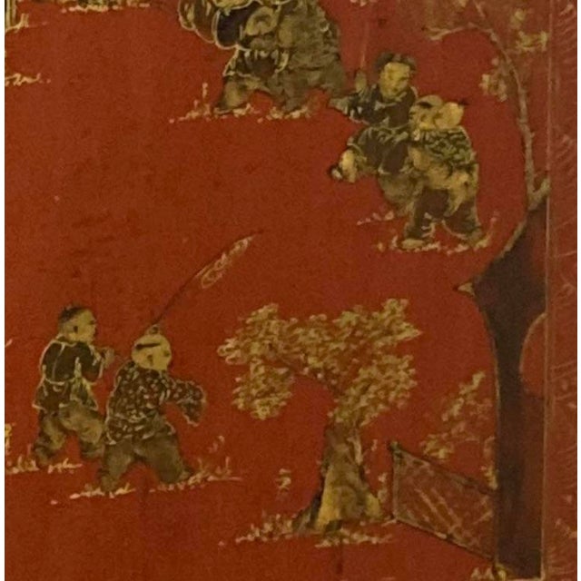 A stunning example of Chinese export red lacquer cabinetry. A hand-painted gilt gold scene adorns this antique Elmwood...