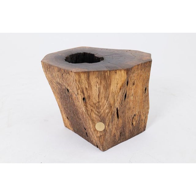 This robust side table is a one of a kind piece, hand carved from a single solid hardwood log. Its blocky, monolithic form...