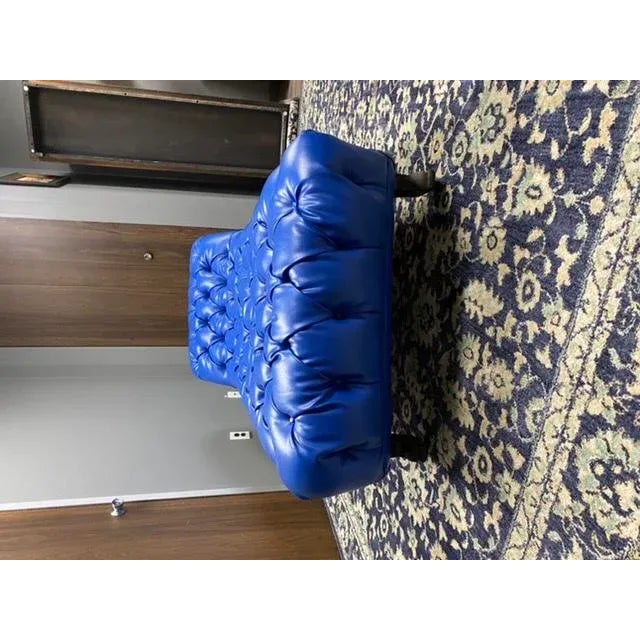 A spectacular antique fainting couch daybed reupholstered in a vibrant royal blue tufted faux leather with nailhead trim....