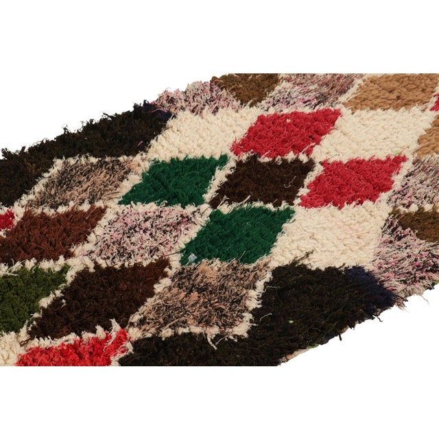 Hand-knotted in wool and originating from Morocco circa 1950-1960, this 3x6 vintage Moroccan rug is an extremely rare...