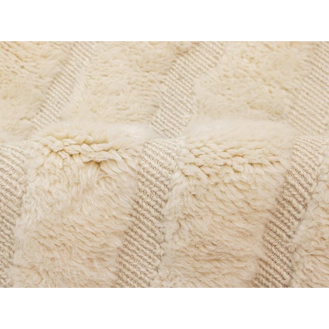 Exquisite hand-knotted wool rug with a handwoven geometric pattern in Ivory, offering depth and a luxurious texture for an...