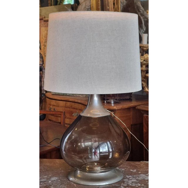 An important Murano-area table lamp, dating back to the 1970s. The body is composed of a large smoked blown glass bubble...