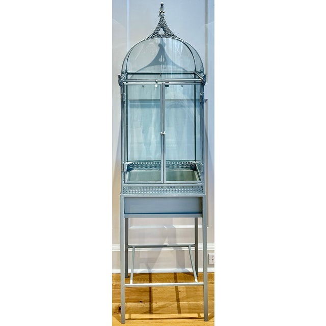 Architectural metal and glass terrarium on stand with Victorian-inspired peaked roof and delicately curved glass panels....
