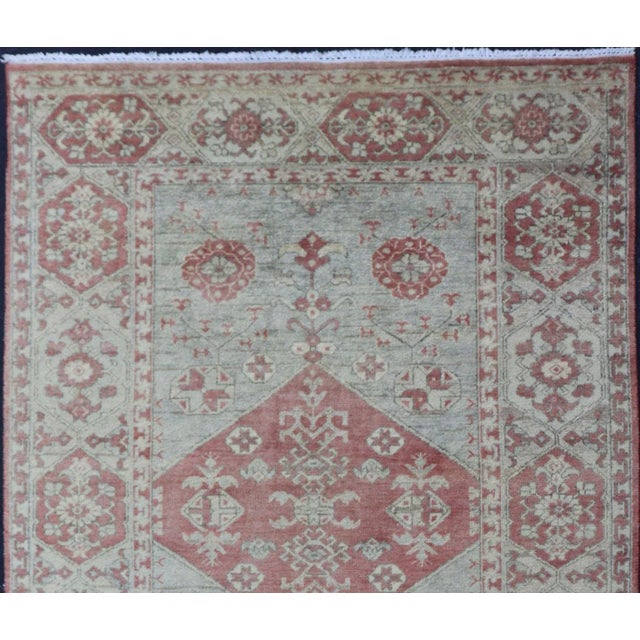 This modern Indian Khotan rug has been hand-knotted in wool and features a floral medallion design rendered in light blue...
