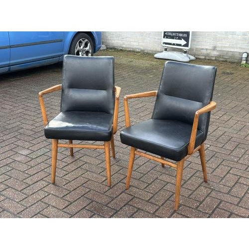 Mid Century Pair Of Library Armchairs Finished in a faux black leather. The chairs are strong and solid, the foam in the...