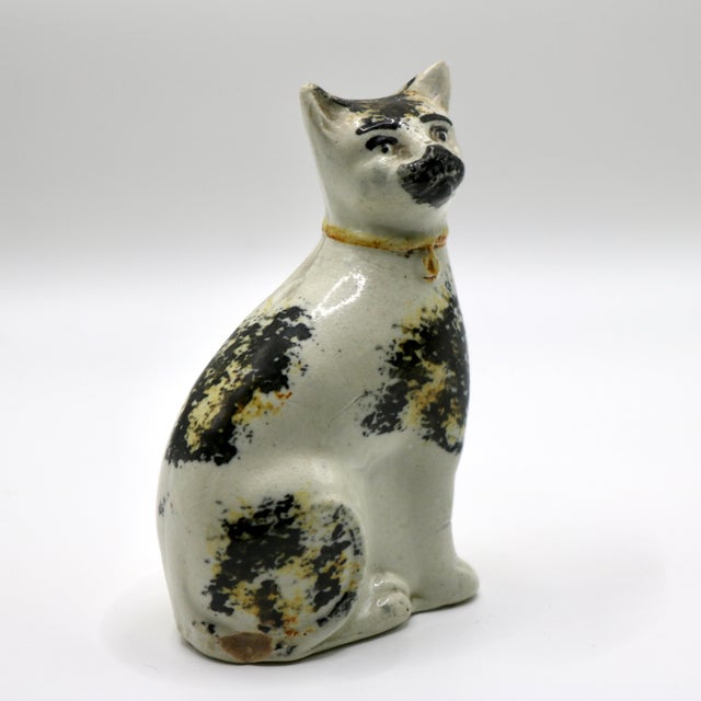 An authentic 19th-century English Staffordshire ceramic cat figure seated upright with an alert expression and charmingly...