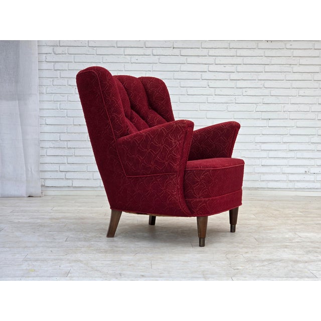 1960s, Danish armchair. Original red furniture fabric, beech wood legs with brass plugs, brass springs in the seat....