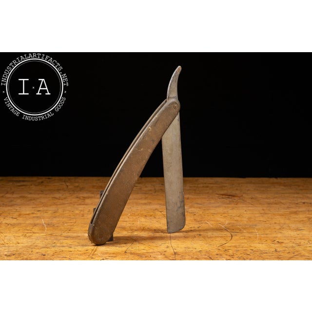 Large-scale figural barber trade sign fashioned in the form of an oversized folding straight razor. Constructed with a...