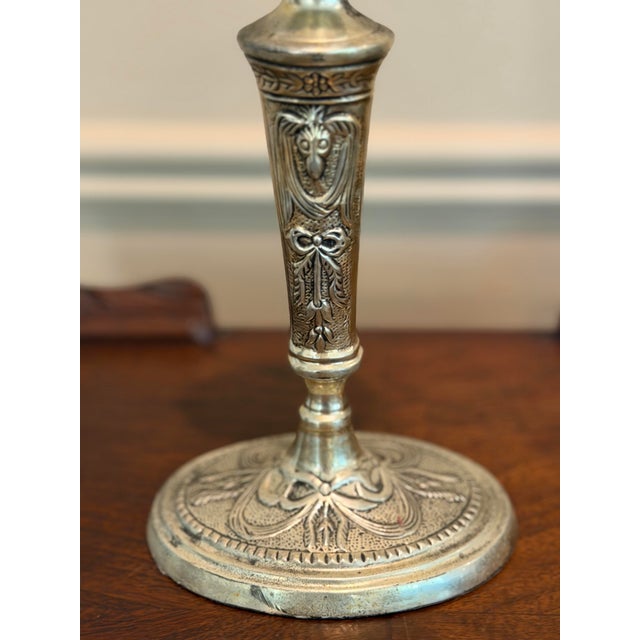 Elegant pair of vintage silverplate candlesticks featuring classical ram’s head medallions, ribbon-and-garland decoration,...