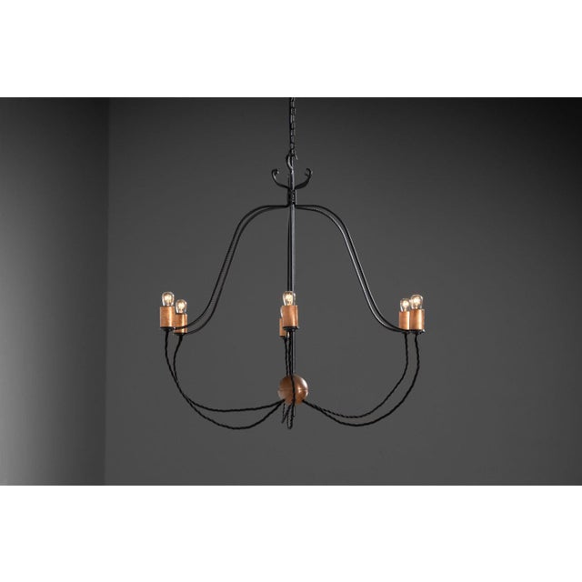 Designed and crafted by Joop Brugman for his own home in Bruchem in 1975, this iron chandelier with copper details stands...