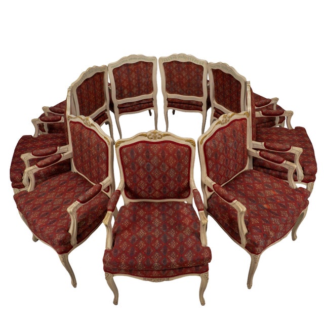 Set of nine French Provincial style dining chairs with classic Louis XV influence. Carved crest rails, cabriole legs, and...