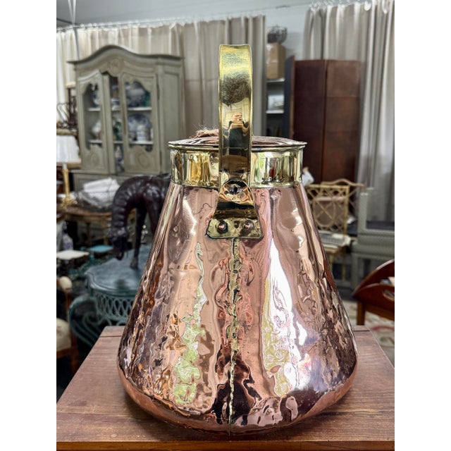 A beautifully hand-crafted antique French water kettle dating to the early 1800s, executed in richly patinated hammered...